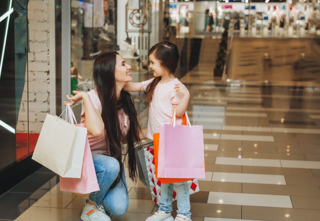 young-mother-and-daughter-holding-shopping-bags-shopping-in-the-mall-family-shopping