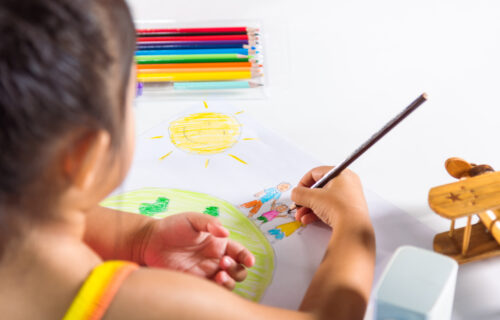 happy-child-little-girl-colorful-drawing-family-standing-hold-hands-on-planet-earth-on-paper-asian-cute-kid-preschooler-sit-on-table-smiling-she-draw-picture-with-pencil-at-home-earth-day-concept